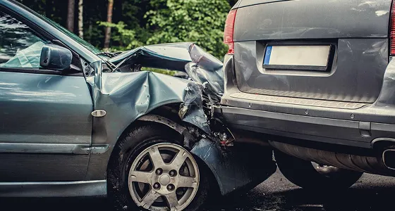 Two cars involved in a rear-end collision with visible front and rear damage.