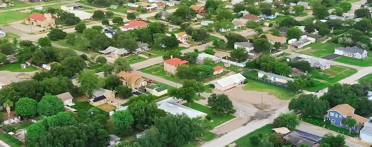 Aerial view of a suburban neighborhood with houses, trees, and streets.
