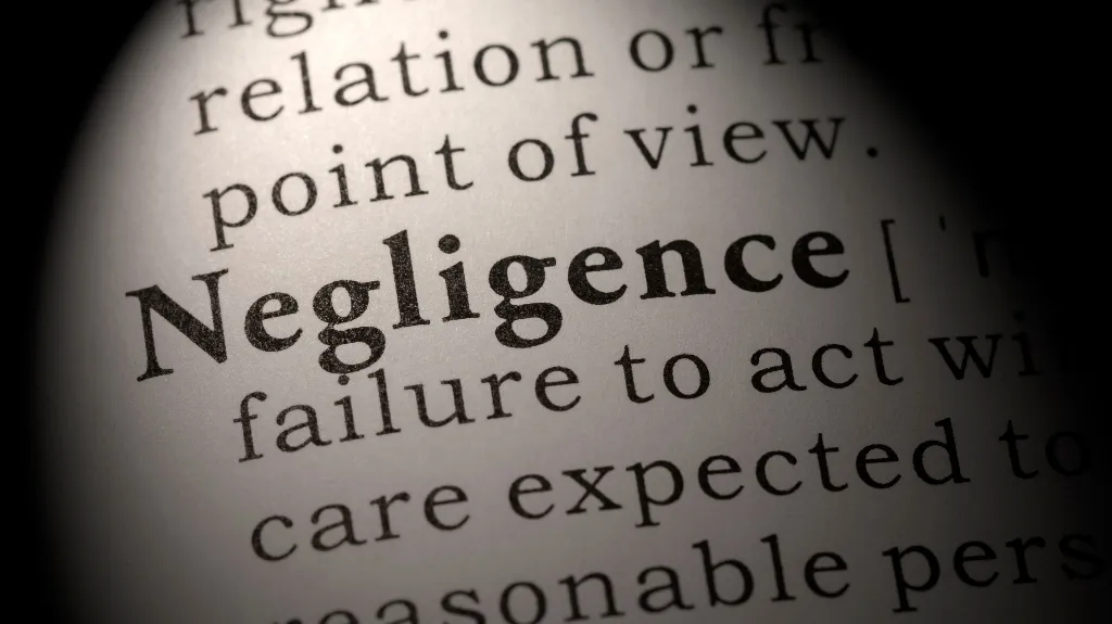 Close-up of a dictionary page highlighting the word "Negligence" in bold text.